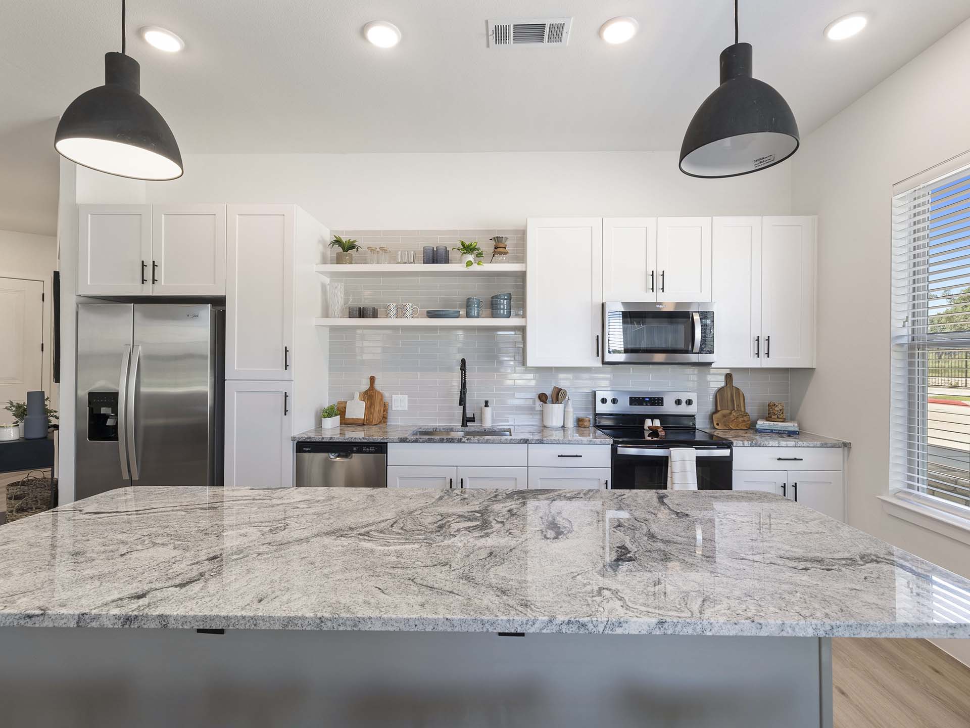 Evergrove apartment kitchen with large island and stainless steel appliances.