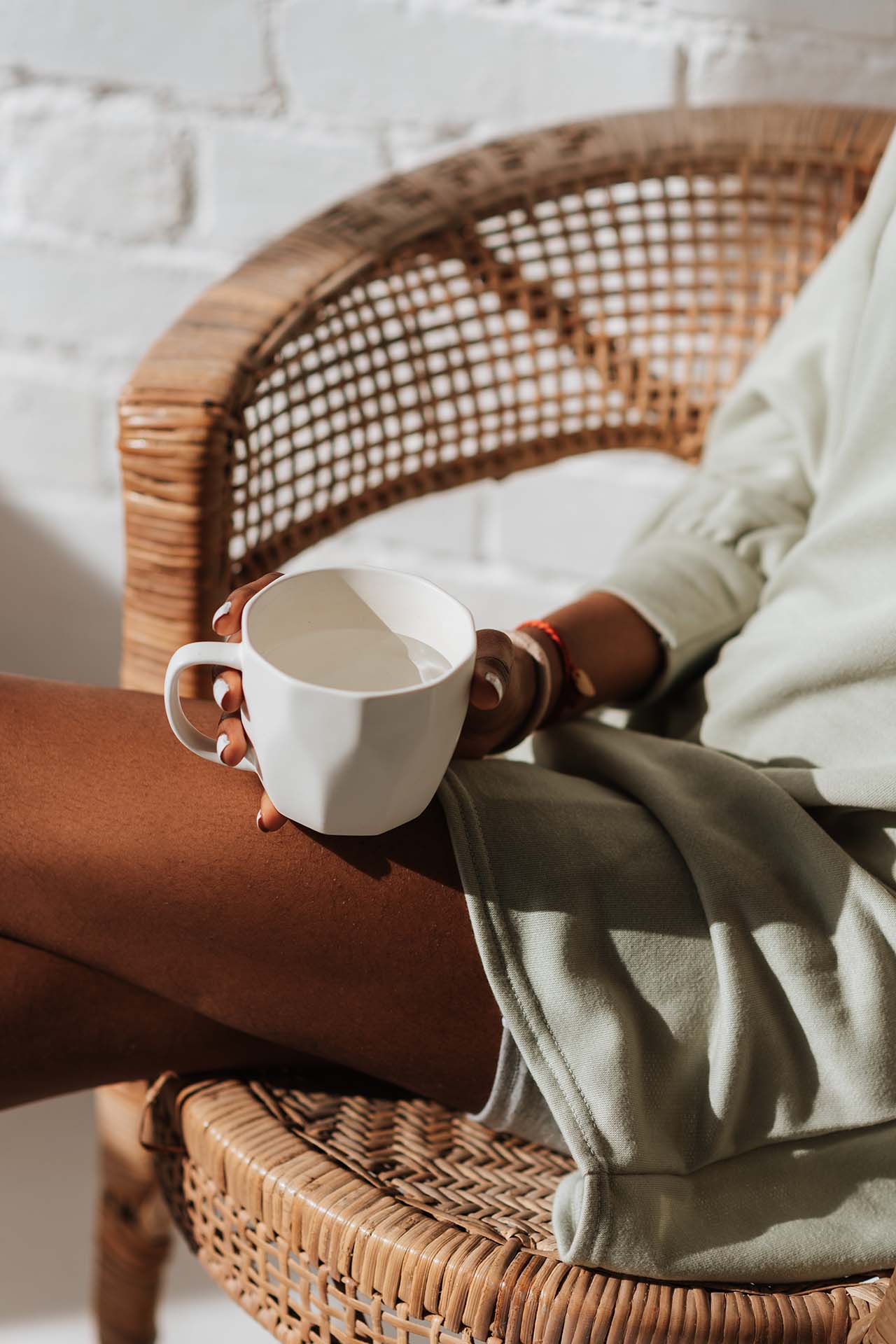 Woman sitting on her balcony drinking coffee